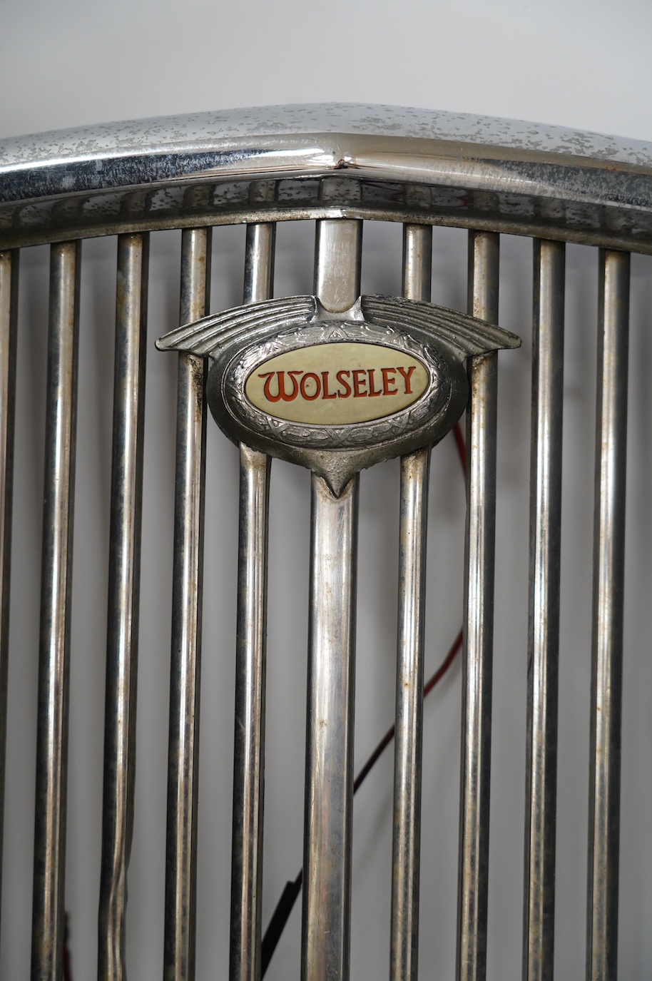 A 1950s Wolseley automobile radiator grill, with a lit logo to the centre of the grill, 40cm x 43cm. Condition - fair to good